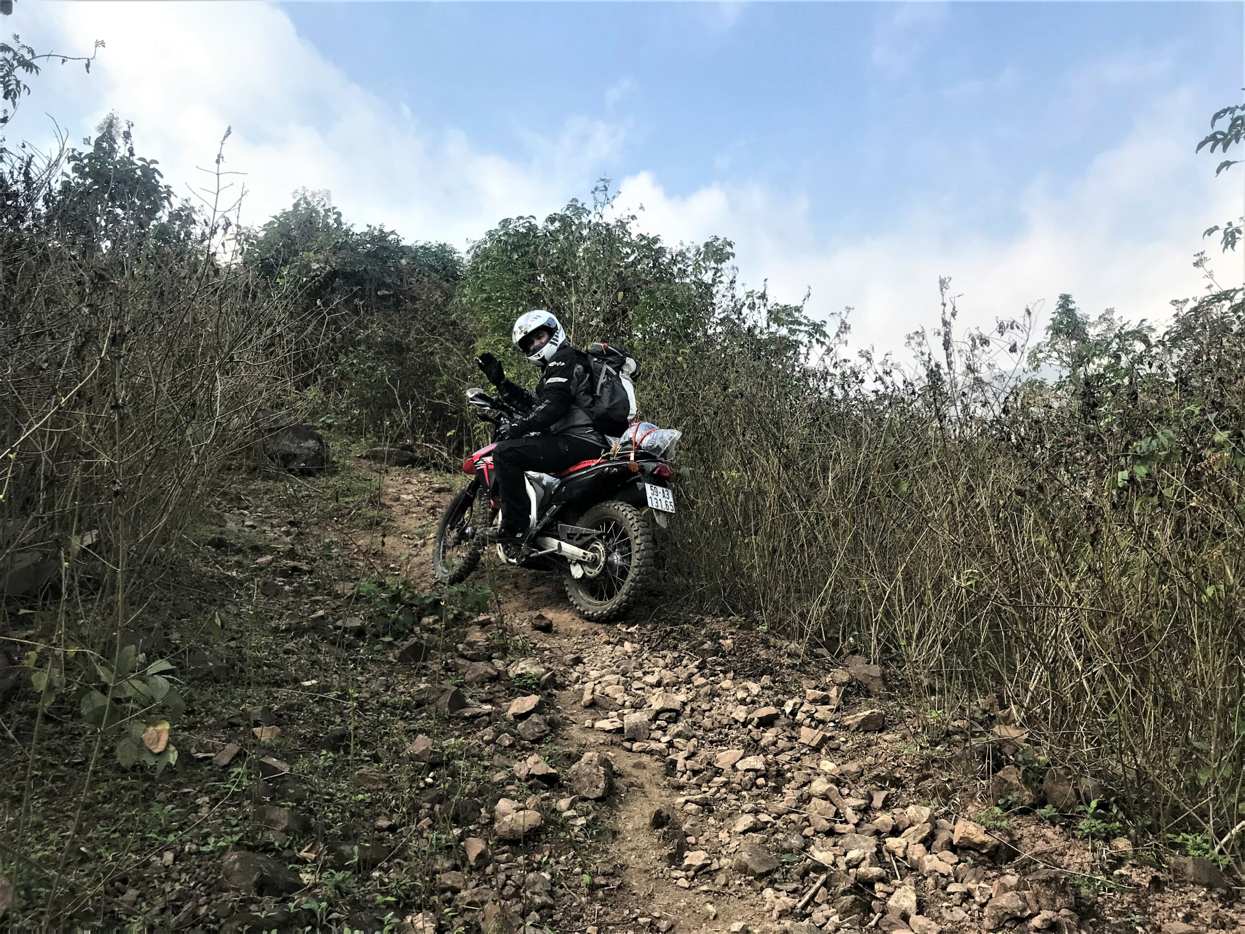 adv rider riding on rocky road on northwest loop vietnam - best motorcycle rides in Vietnam